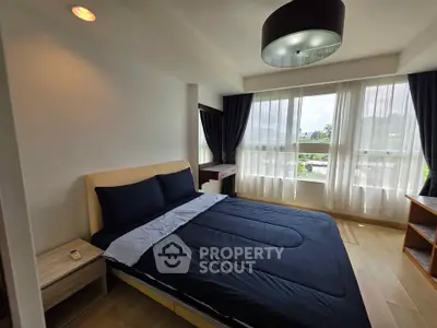 Modern bedroom with large window and stylish decor, featuring a comfortable bed and natural light.