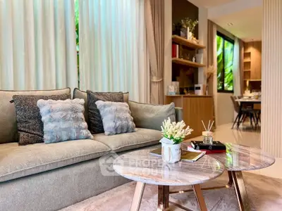 Luxurious living room with elegant decor and natural light, featuring plush sofa and stylish coffee tables.