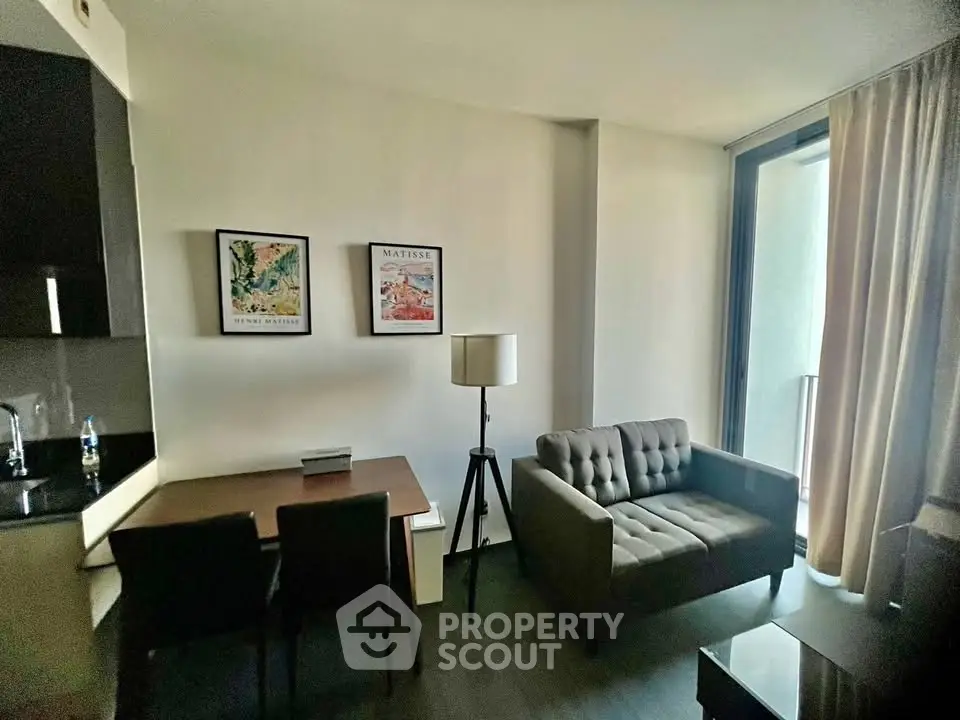 Modern living room with stylish decor and natural light, featuring a cozy sofa and dining area.