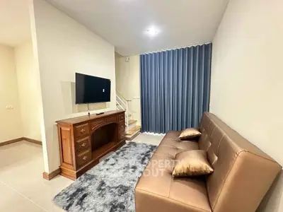 Cozy living room with modern sofa, TV, and elegant decor in a stylish apartment.