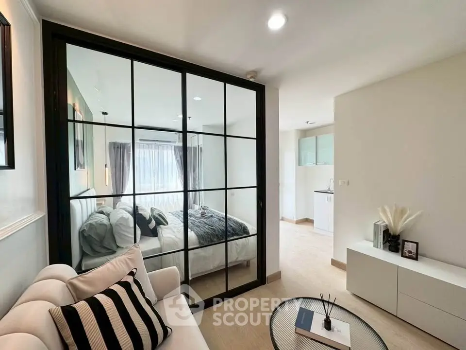 Modern apartment interior with stylish living room and cozy bedroom separated by glass partition.