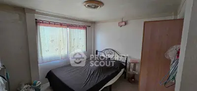 Cozy bedroom with natural light and simple furnishings, ideal for a peaceful retreat.