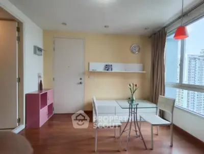 Bright living room with modern furniture and large window offering city view.