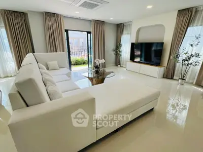 Luxurious modern living room with elegant white sofa and large TV, perfect for relaxation.