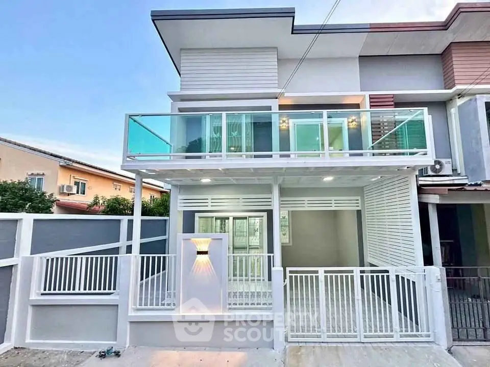 Modern two-story house with glass balcony and sleek exterior design