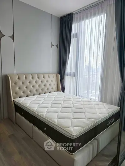 Luxurious bedroom with elegant bed and large window offering natural light