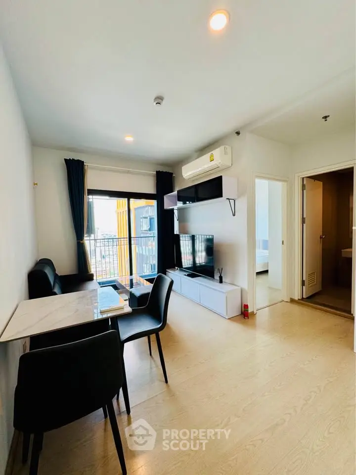 Modern living room with dining area and balcony view in a stylish apartment.