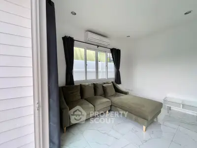 Modern living room with sleek sofa and air conditioning, featuring large windows and elegant curtains.
