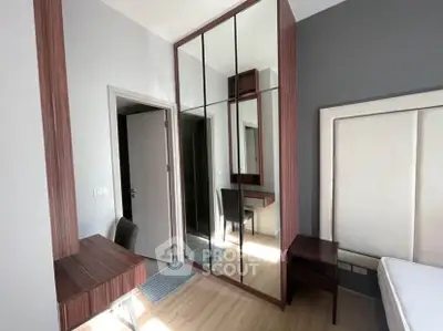 Modern bedroom with mirrored wardrobe and sleek wooden furniture