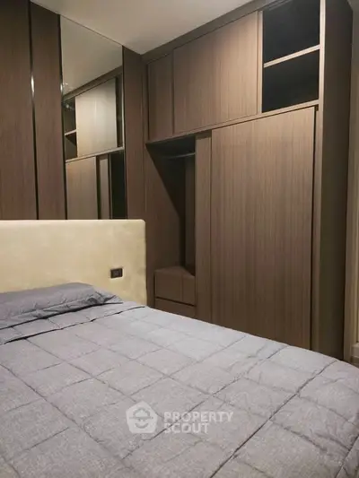 Modern bedroom with sleek wooden wardrobe and cozy bed setup