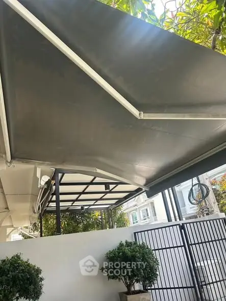 Modern outdoor entrance with sleek awning and potted plants