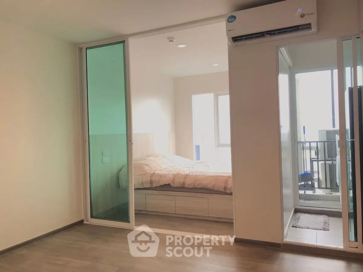 Modern bedroom with sliding glass doors and balcony access in a stylish apartment.