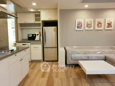 Modern open-layout kitchen and living room with sleek appliances and stylish decor.