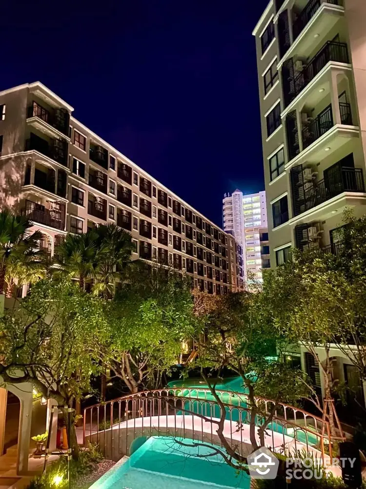 Luxurious apartment complex with lush garden and inviting pool under a starry night sky, offering a serene urban oasis.