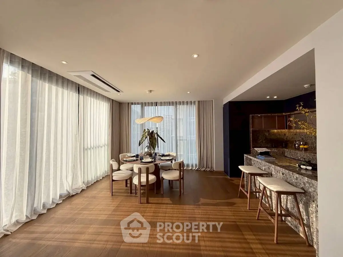 Elegant dining area with natural light and modern decor in a spacious open layout.