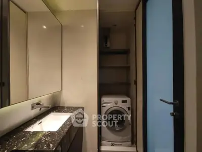 Modern bathroom with sleek design featuring a built-in washing machine and elegant marble countertop.