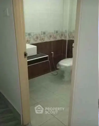 Compact bathroom with modern fixtures and floral tile accents