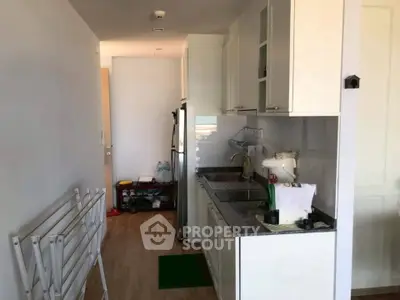 Compact kitchen with modern white cabinets and granite countertops in cozy apartment