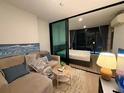 Modern studio apartment with cozy living area and bedroom separated by glass partition.