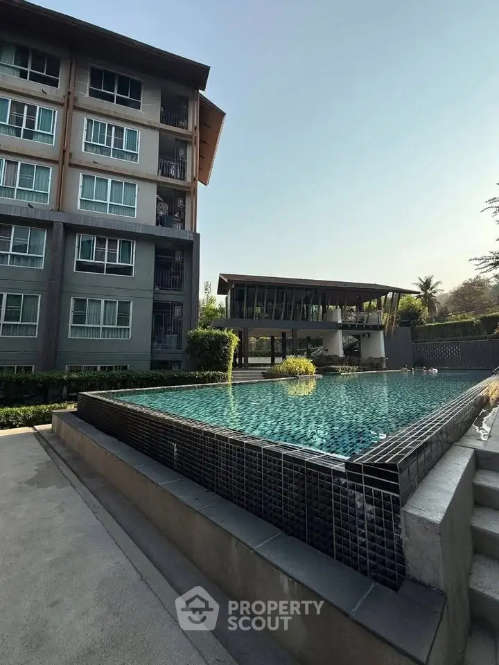 Modern apartment building with a luxurious pool and stylish outdoor area.