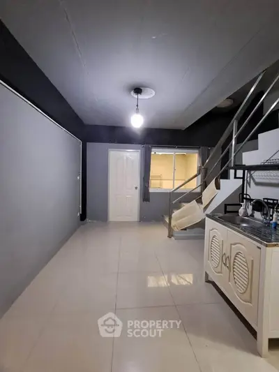 Modern interior with sleek staircase and compact kitchen area, perfect for urban living.