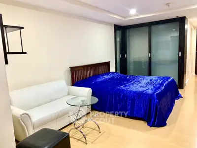 Spacious bedroom with modern furnishings and elegant decor, featuring a cozy bed and stylish seating area.