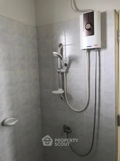 Modern bathroom with electric shower and tiled walls