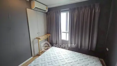 Cozy bedroom with air conditioning and natural light through window, featuring a minimalist design.