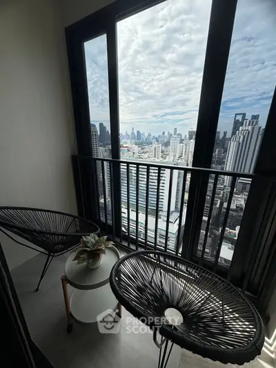 Stunning city view from a modern high-rise balcony with stylish seating.