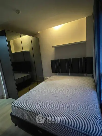 Modern bedroom with sleek mirrored wardrobe and cozy lighting