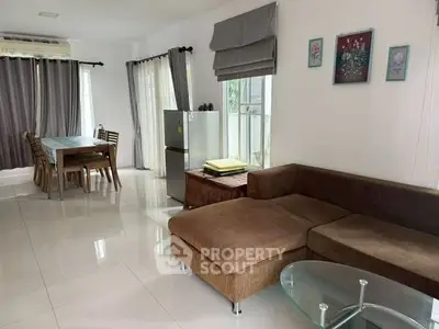 Spacious living room with modern furniture and dining area, featuring natural light and stylish decor.
