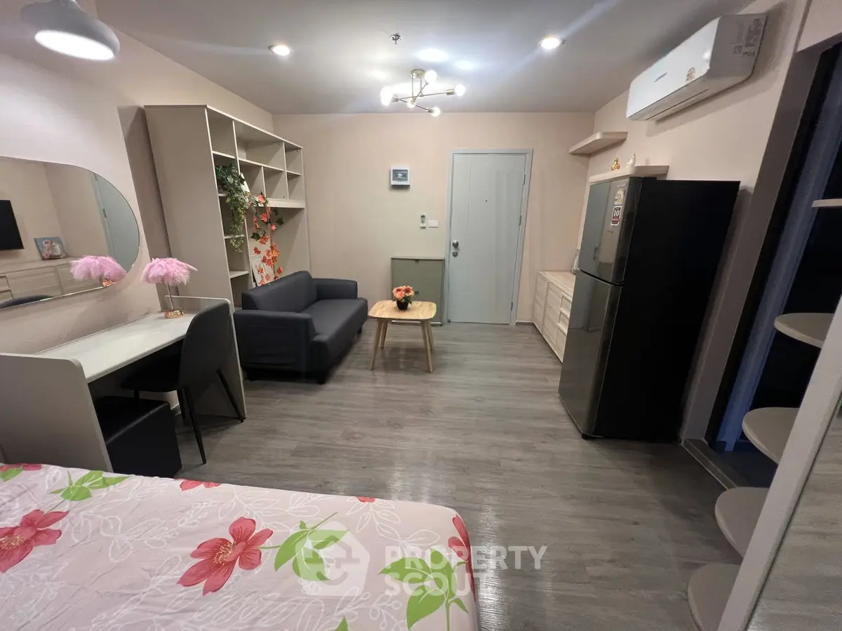 Modern studio apartment with stylish decor and open layout, featuring a cozy living area and compact kitchen.