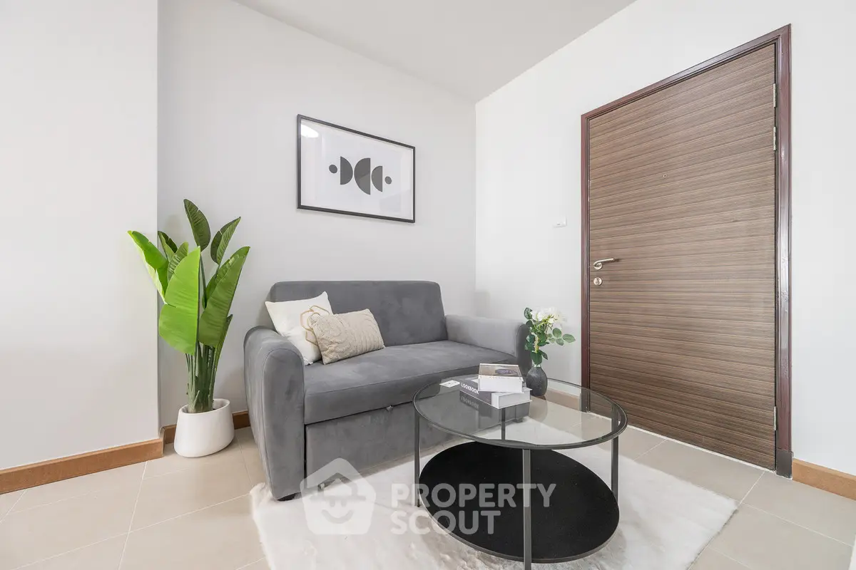 Modern living room with stylish gray sofa, elegant decor, and sleek wooden door.
