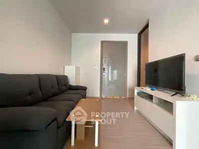 Modern living room with sleek furniture and flat-screen TV, perfect for relaxation.