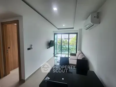 Modern living room with sleek furniture and large windows offering natural light and greenery view.