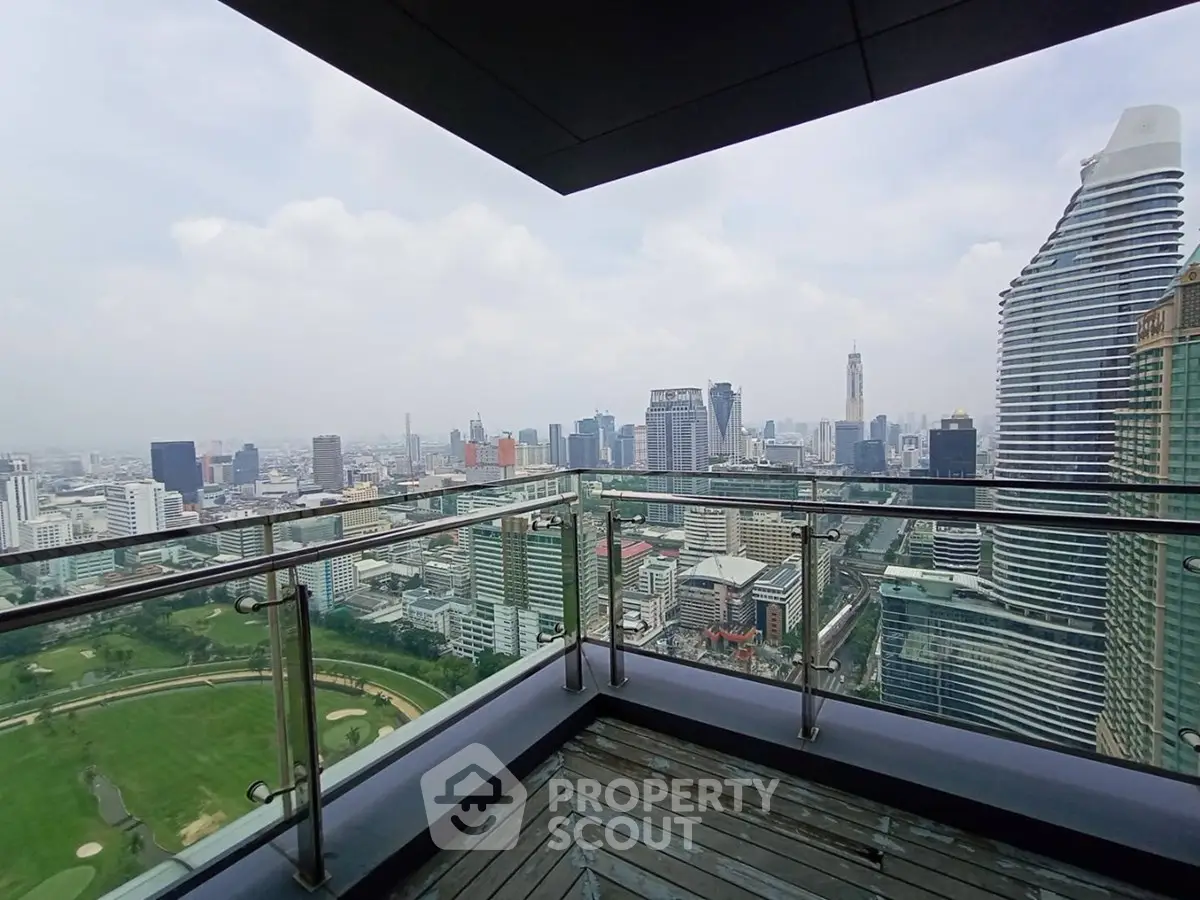Stunning cityscape view from a high-rise balcony overlooking urban skyline and golf course.