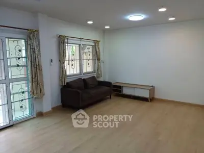 Spacious living room with wooden flooring and natural light