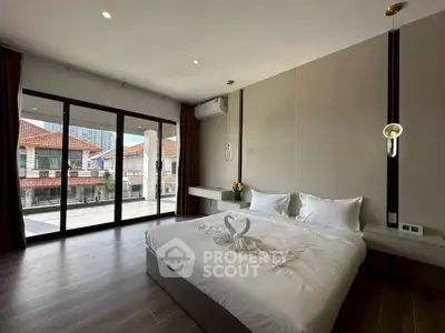 Spacious modern bedroom with large windows and elegant decor in a luxury home.
