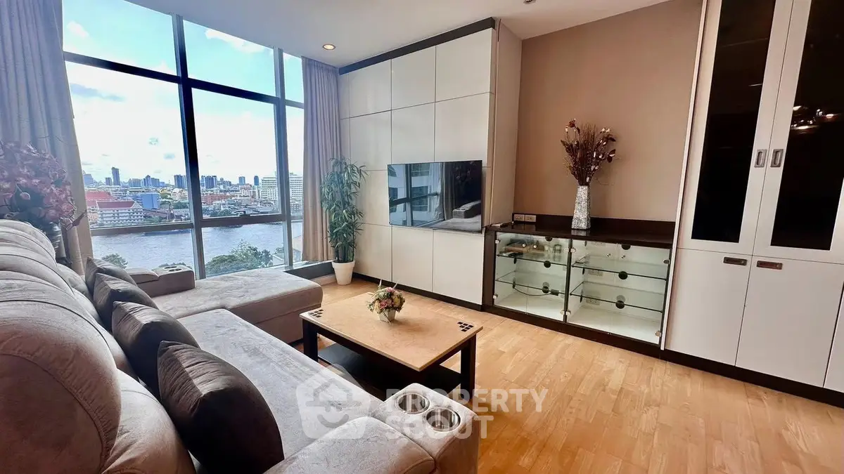 Luxurious living room with stunning river view, modern furniture, and elegant decor in high-rise apartment.