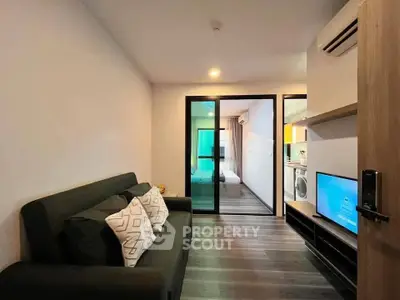 Modern living room with sleek design, featuring a cozy sofa and open view into a stylish bedroom.