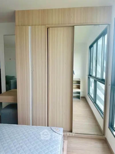Modern bedroom with large windows and built-in wardrobe in a bright apartment.