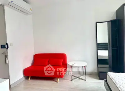 Modern minimalist bedroom with red sofa and sleek furnishings