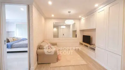 Charming living room with cozy sofa and elegant built-in cabinetry, adjacent to a serene bedroom retreat.