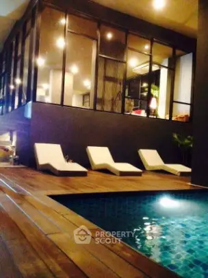 Luxurious modern poolside area with sleek design and elegant lounge chairs.