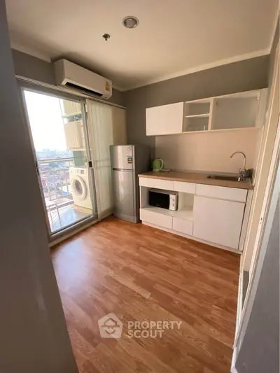 Modern compact kitchen with appliances and balcony view