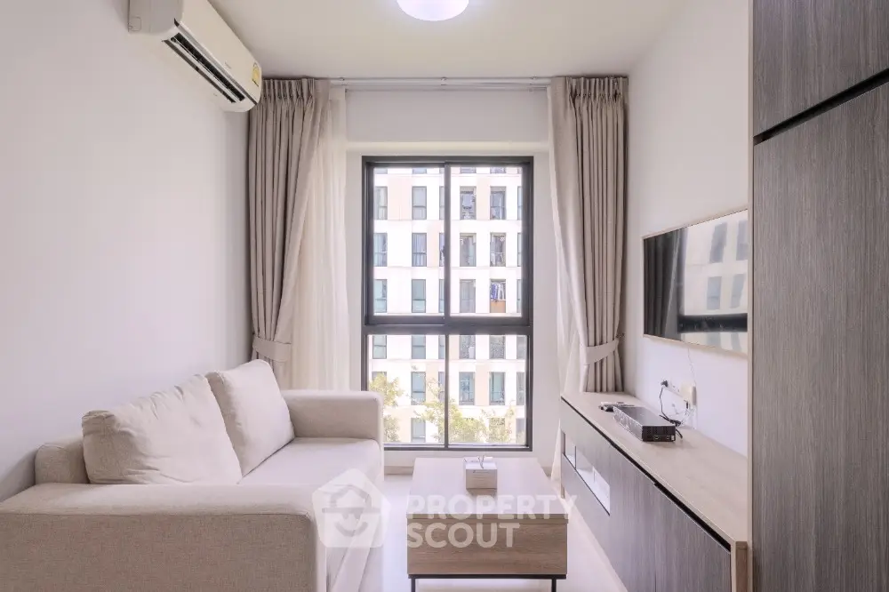 Modern living room with cozy sofa and large window view in stylish apartment.