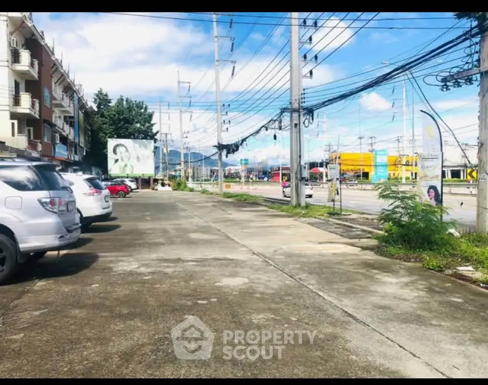 Spacious parking area in front of commercial buildings with clear blue sky.