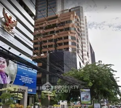 Modern commercial building exterior with lush greenery and urban surroundings.