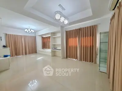 Spacious living room with modern lighting and large windows, perfect for family gatherings.