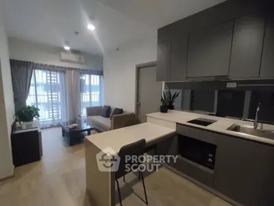 Modern open-layout kitchen and living room with sleek design and natural light.
